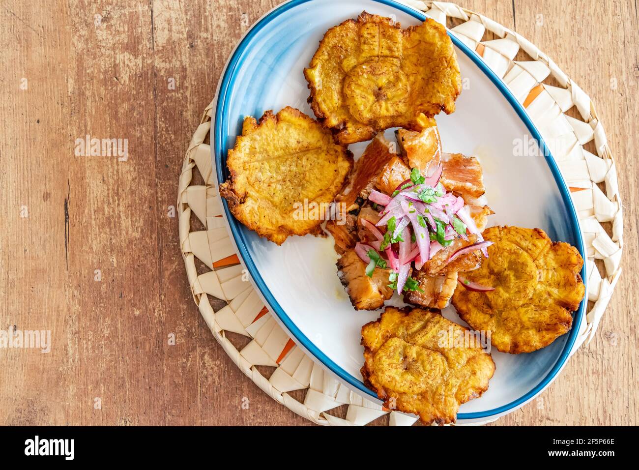 un piatto di plantain fritto servito con manzo grattugiato a gocce con condimento di cipolla e lime Foto Stock