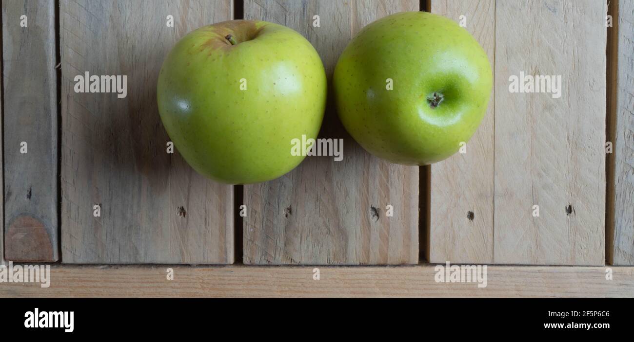 Mele verdi su tavola di legno Foto Stock
