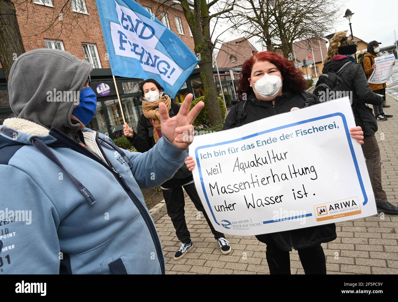 Rostock, Germania. 27 Marzo 2021. In occasione di una dimostrazione "UN nuovo sguardo al pesce", un partecipante porta un cartello con la scritta "sono per la fine della pesca, perché l'acquacoltura è un'azienda agricola in acqua". L'azione si è svolta nell'ambito della campagna mondiale "UN nuovo sguardo al pesce" e della V Giornata Mondiale per la fine della pesca. I capitoli locali dell'organizzazione per i diritti degli animali Animal Rights Watch (ARIWA) avevano chiesto l'azione. Foto: Stefan Sauer/dpa Credit: dpa Picture Alliance/Alamy Live News Foto Stock