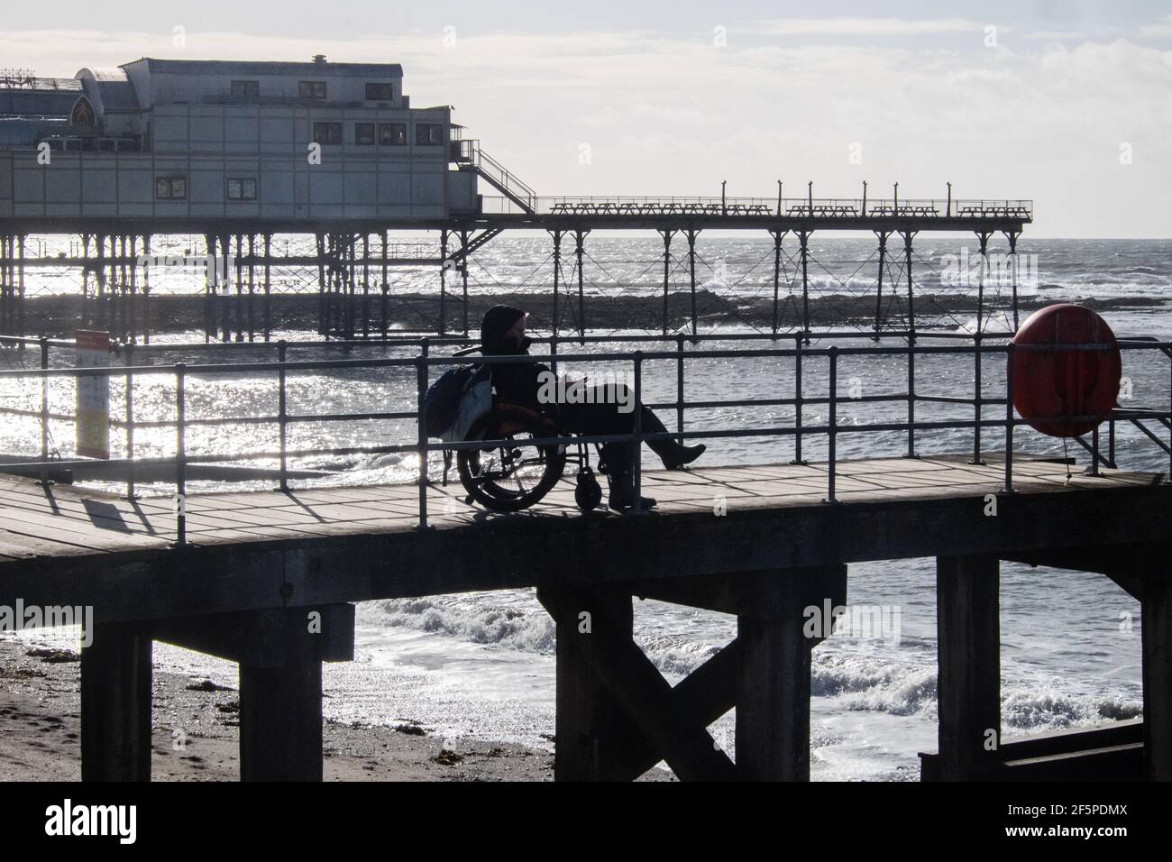 Ragazzo, maschio, in, una, sedia a rotelle, sedia a rotelle. Le ruote non possono accedere ai gradini, alle scale, alla spiaggia. Immagine scattata venerdì 27 marzo 2021, ultimo giorno di blocco. Dal 27 marzo 2021 i residenti gallesi sono stati autorizzati a viaggiare ovunque nel Galles come soggiorno locale, e prima di quel soggiorno a casa regole sono state demolite.come uscire, all'aperto, è stato visto come un buon modo di migliorare la salute mentale durante lockdown.Irish Sea, Water, Aberystwyth, Cardigan Bay, studente, università, costa, città, in, Ceredigon, Regno Unito, Galles, Gran Bretagna, Gran Bretagna, Galles, Gran Bretagna, Gran Bretagna, Galles, Gran Bretagna, Galles, Gran Bretagna, Gran Bretagna, Galles, Gran Bretagna, Gran Bretagna, Galles, Gran Bretagna, Galles, Gran Bretagna, Gran Bretagna, Galles, Foto Stock