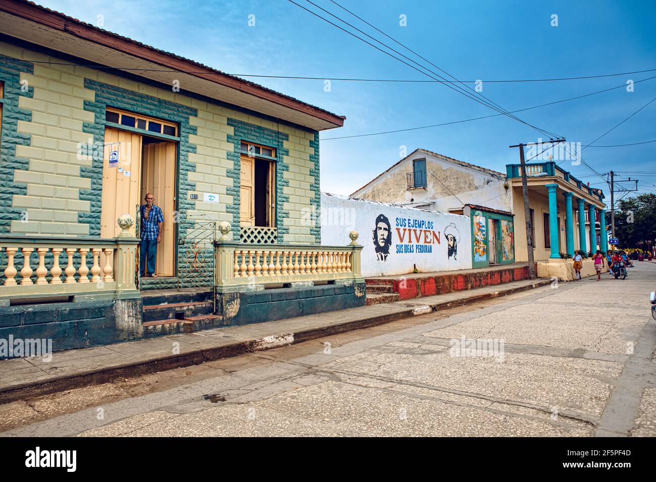 Baracoa, Cuba - 25 ottobre 2019: Vecchio cubano di fronte al suo alloggio (casa Particular) a Baracoa con propaganda comunista dipinta e che Foto Stock