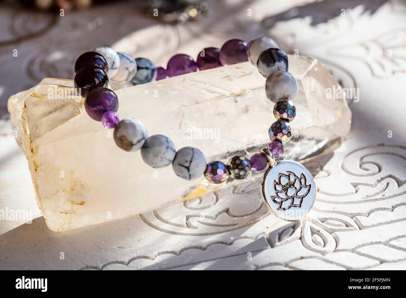 Braccialetto yoga con perline di pietra minerale su sfondo naturale neutro Foto Stock