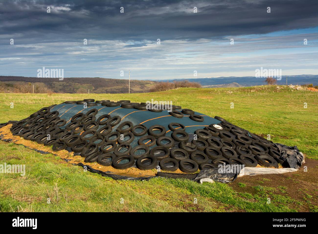 Vecchi pneumatici su un mucchio di insilato, Auvergne-Rhones-Alpes, Francia Foto Stock