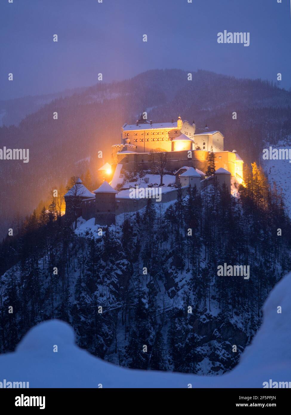 Burg Hohenwerfen a Salisburgo in Oesterreich im Winter in der blauen Stunde. Castello di Salisburgo in Austria in inverno. Foto Stock