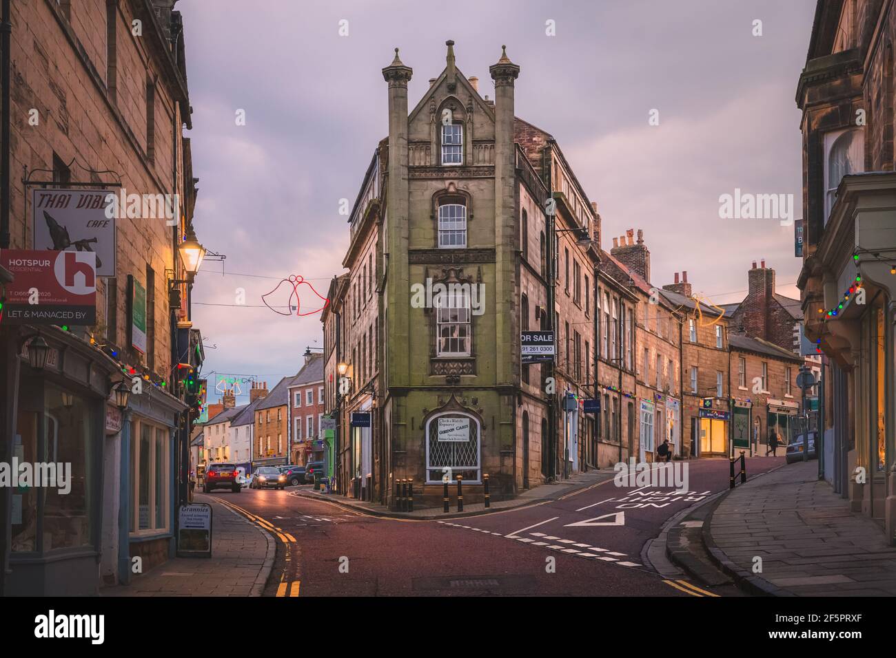 Alnwick, Inghilterra - 8 dicembre 2018: Tramonto d'oro o luce dell'alba sul centro del villaggio e la strada alta della città vecchia di Alnwick in Northumberland, Englan Foto Stock