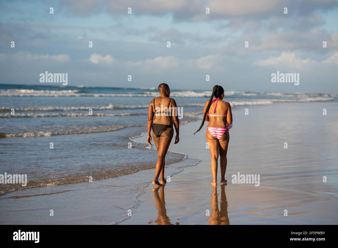 Due Signore che camminano sulla spiaggia Foto Stock