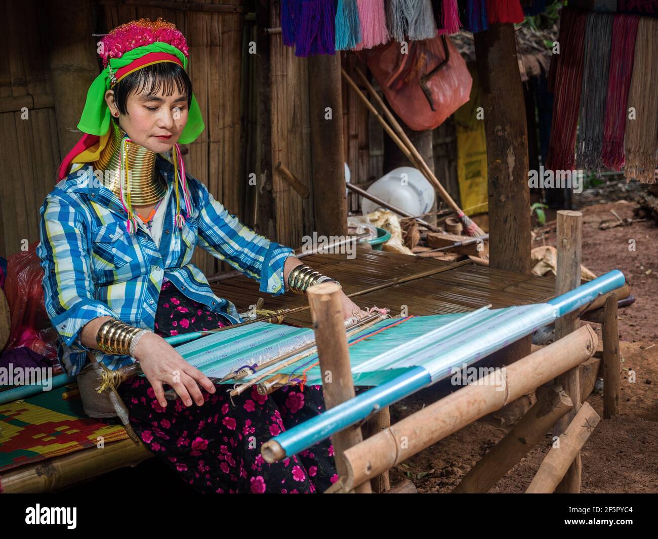 Karen donna a collo lungo indossa tradizionali anelli di ottone e tessere uno scialle in un villaggio di tribù collina vicino Chiang mai, Thailandia. Foto Stock