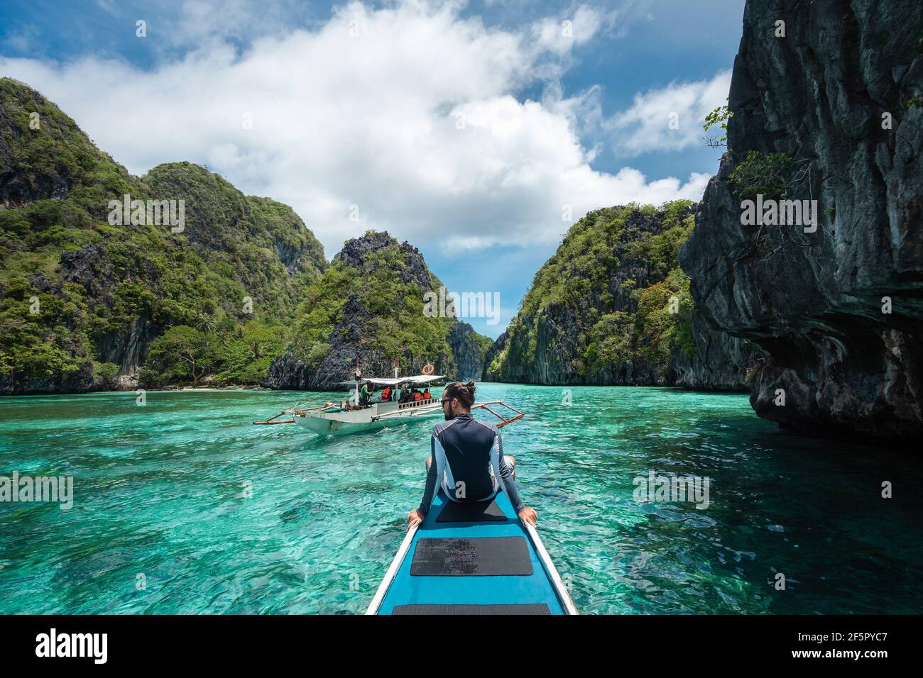 El Nido, Palawan, Filippine, viaggiatore seduto sul ponte della barca per esplorare le attrazioni naturali intorno a El Nido in una giornata di sole. Foto Stock