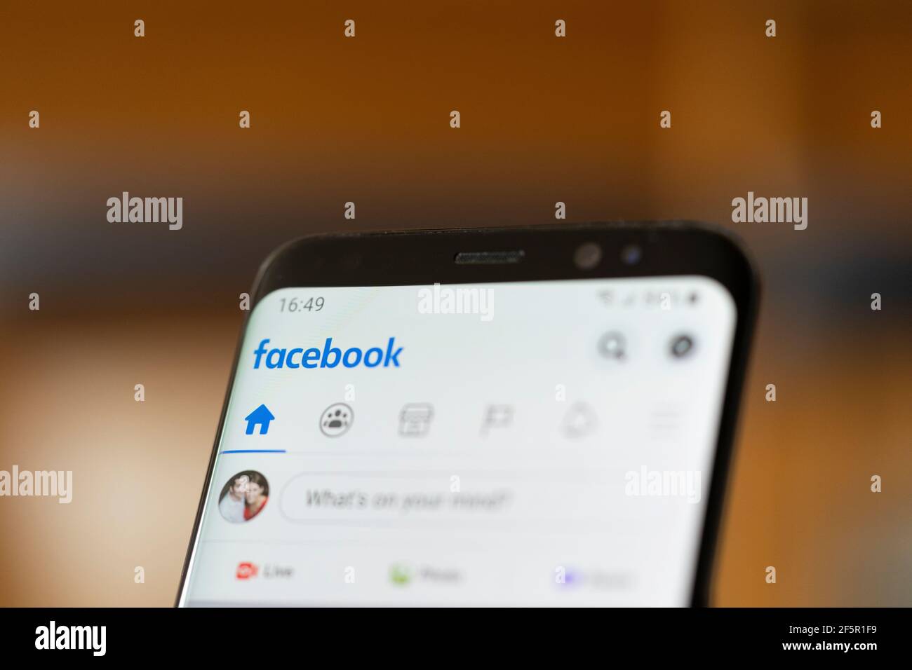 Primo piano sullo schermo di uno smartphone Android che mostra il social di Facebook logo e home page dell'app multimediale Foto Stock
