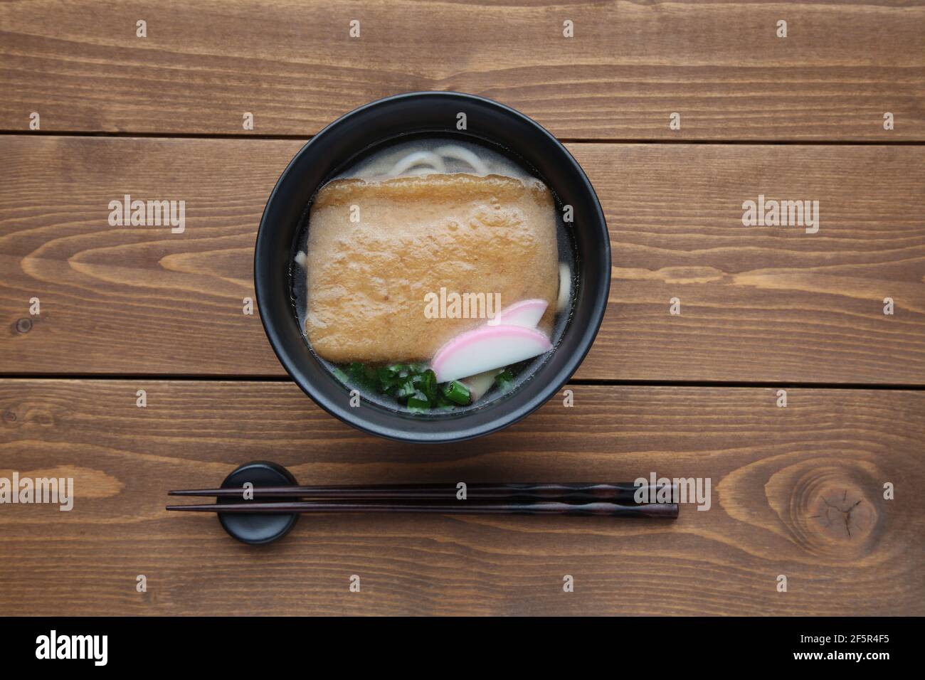 Tagliatelle giapponesi con tofu fritto isolato su legno tabella Foto Stock