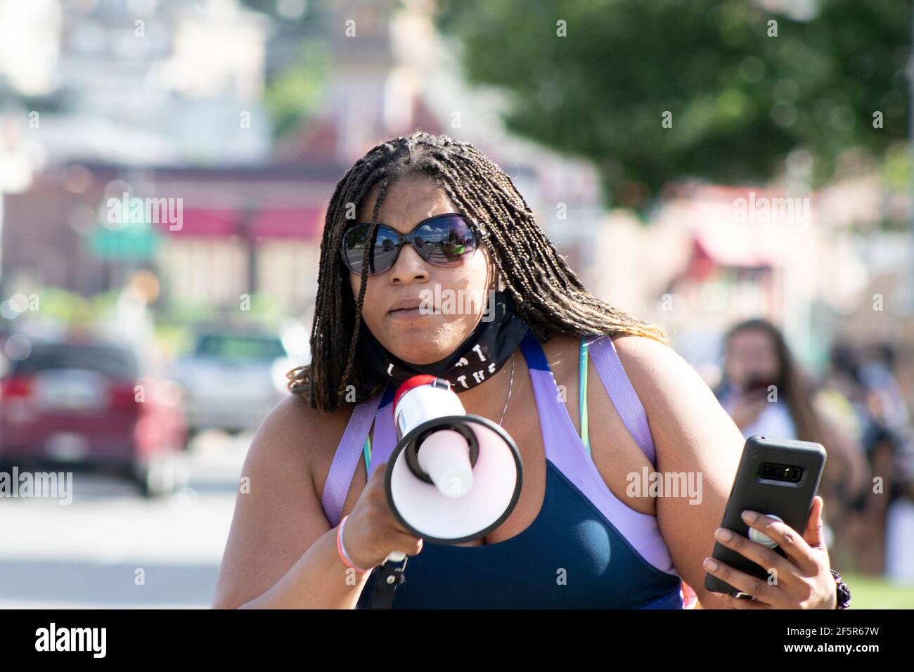 African American Woman con trecce e occhiali da sole che conducono la vita nera La questione protesta con Megaphone Foto Stock