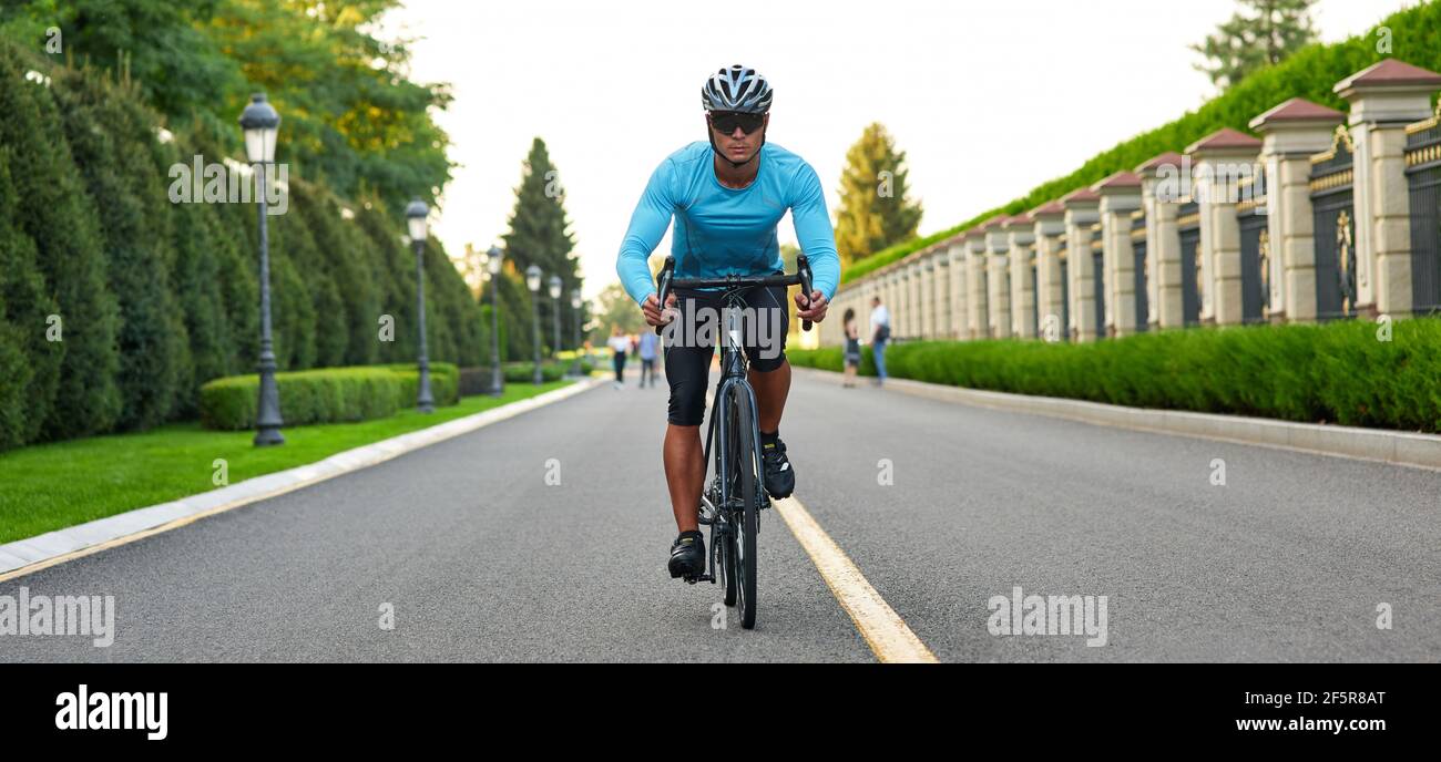 Intestazione del sito web di un uomo che cavalcano in mountain bike nel parco durante il tramonto, in bicicletta all'aperto in una giornata estiva Foto Stock