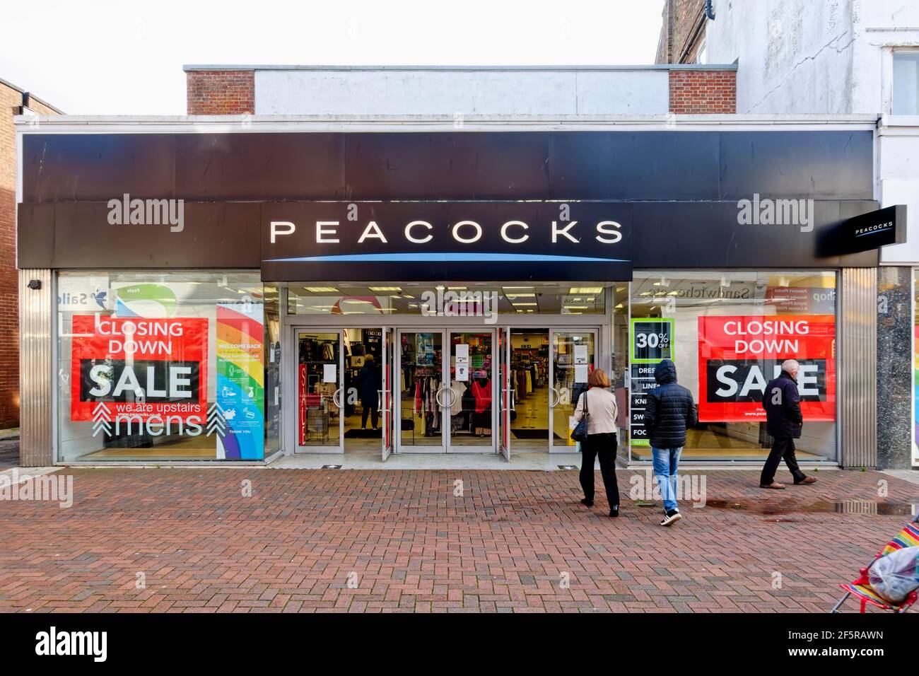 Poole, Dorset UK - 3 novembre 2020: Chiusura dei manifesti di vendita esposti nelle finestre della catena di negozi di abbigliamento fast-fashion pavocks Foto Stock