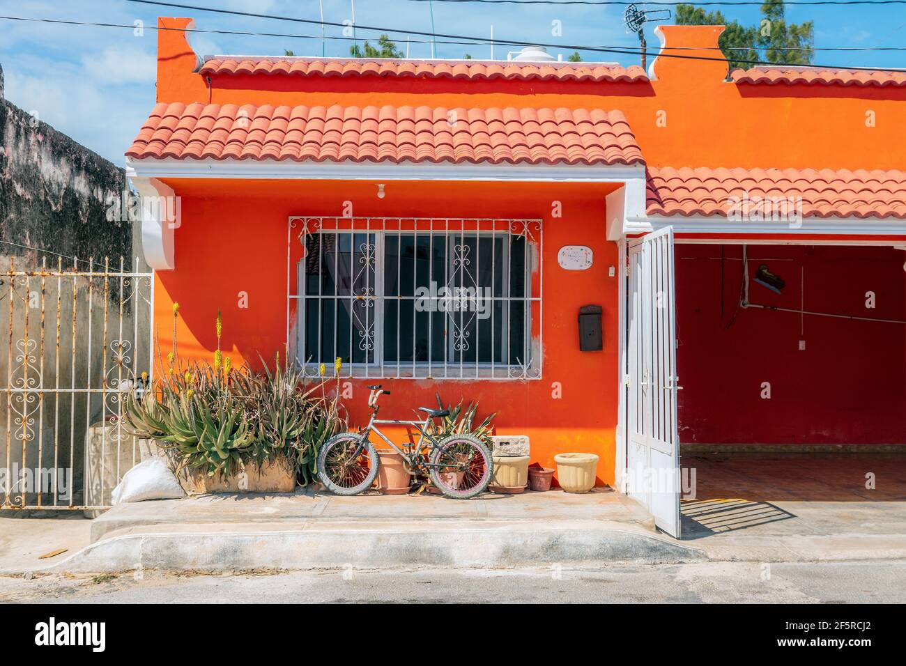 Graziosa casa arancione - un esempio di architettura dai colori vivaci E case in Messico Foto Stock
