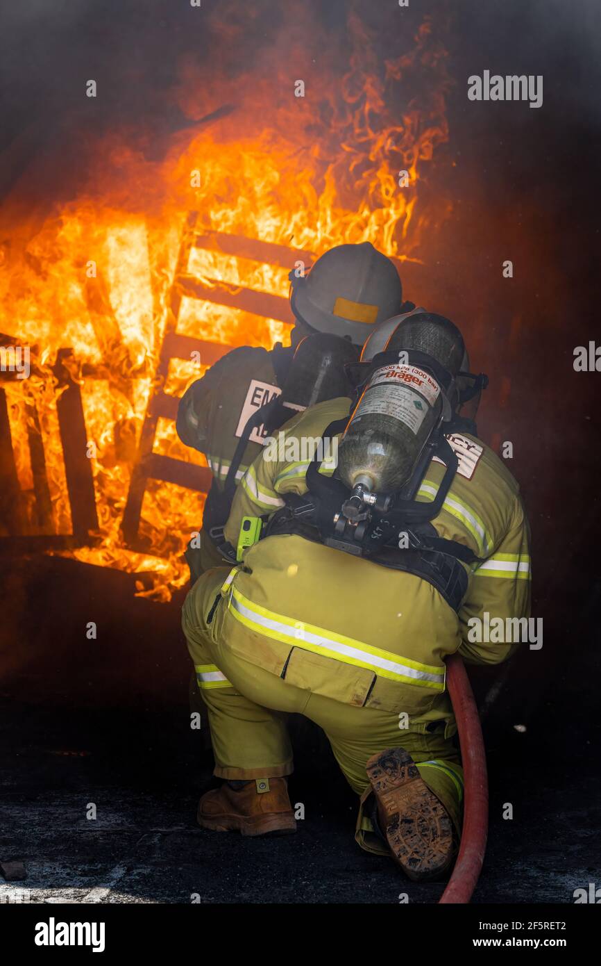 Il team di risposta alle emergenze minerarie in indumenti protettivi e apparecchi respiratori che praticano attività antincendio e di soccorso in caso di incidenti sul campo di fuoco. Foto Stock