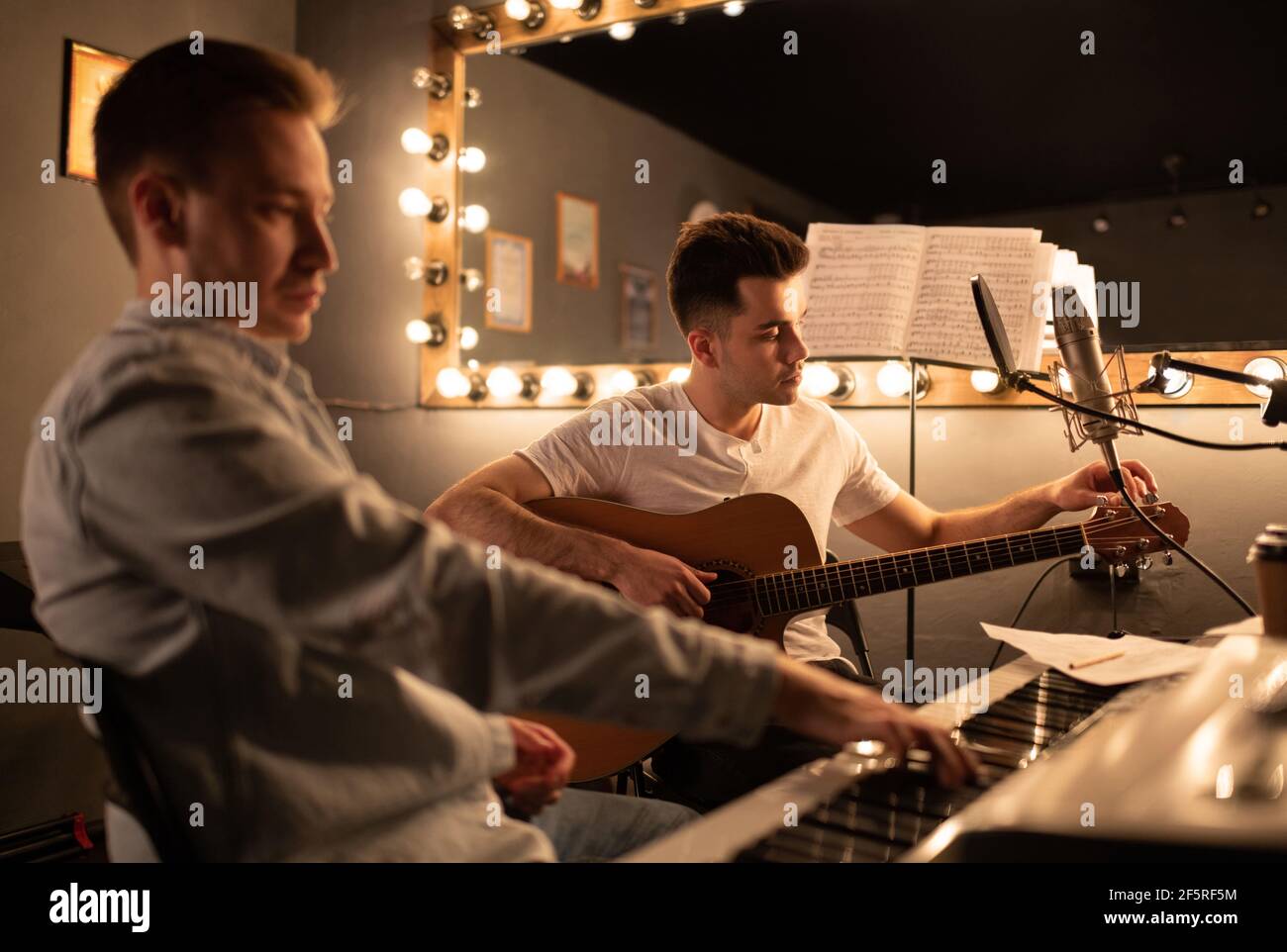 Musicisti maschili accordano strumenti in studio Foto Stock