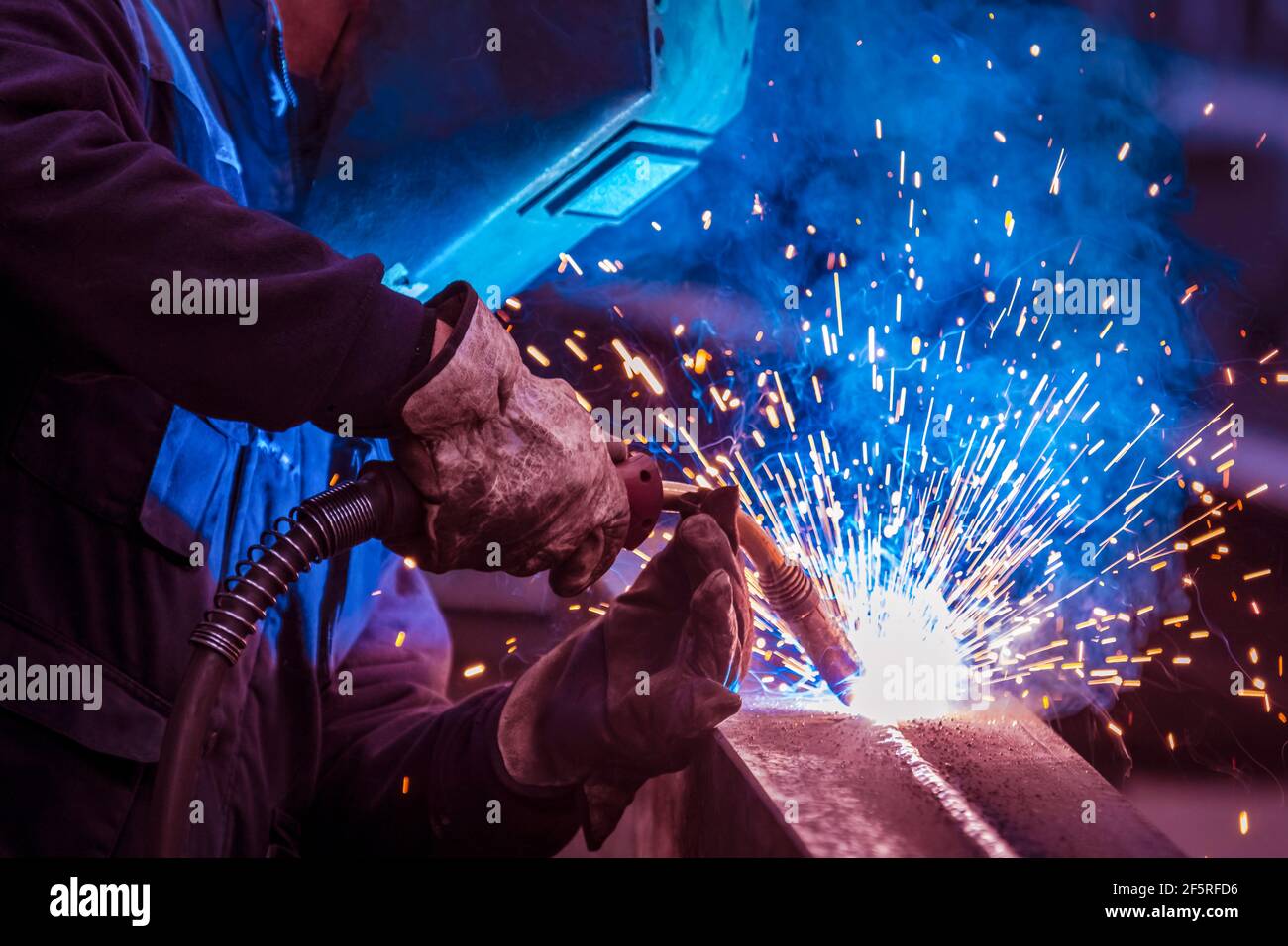 Uomo con protezione viso e occhi saldante in acciaio Foto Stock