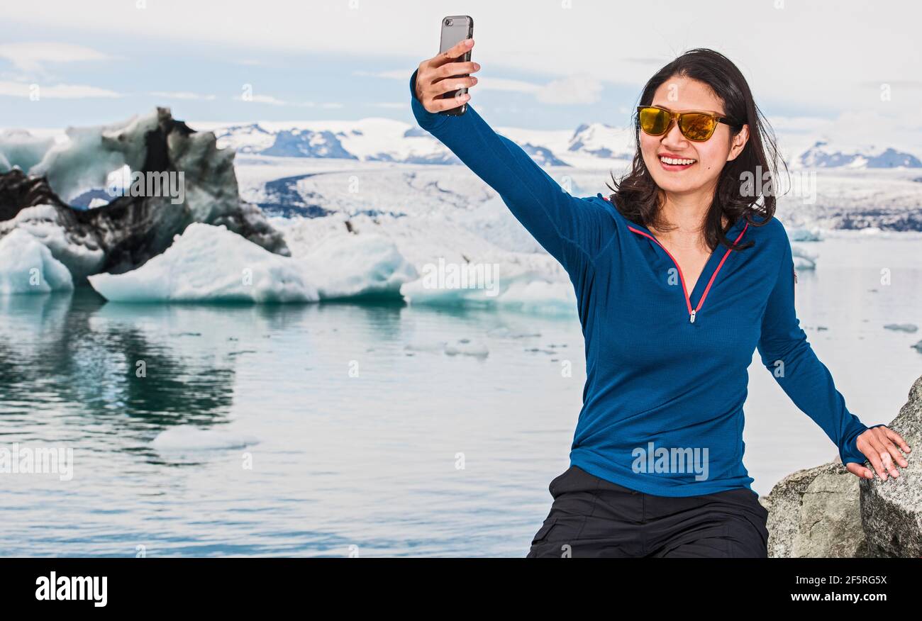 Donna che prende selfie alla laguna glaciale Jökulsárlón in Islanda Foto Stock