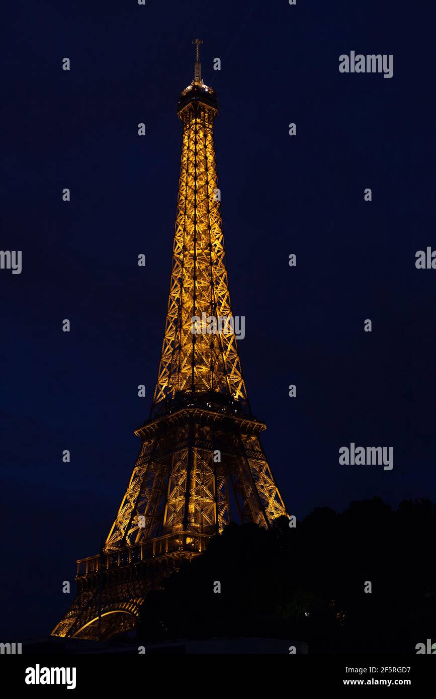 Vista iconica della Torre Eiffel illuminata di notte da La Senna Foto Stock