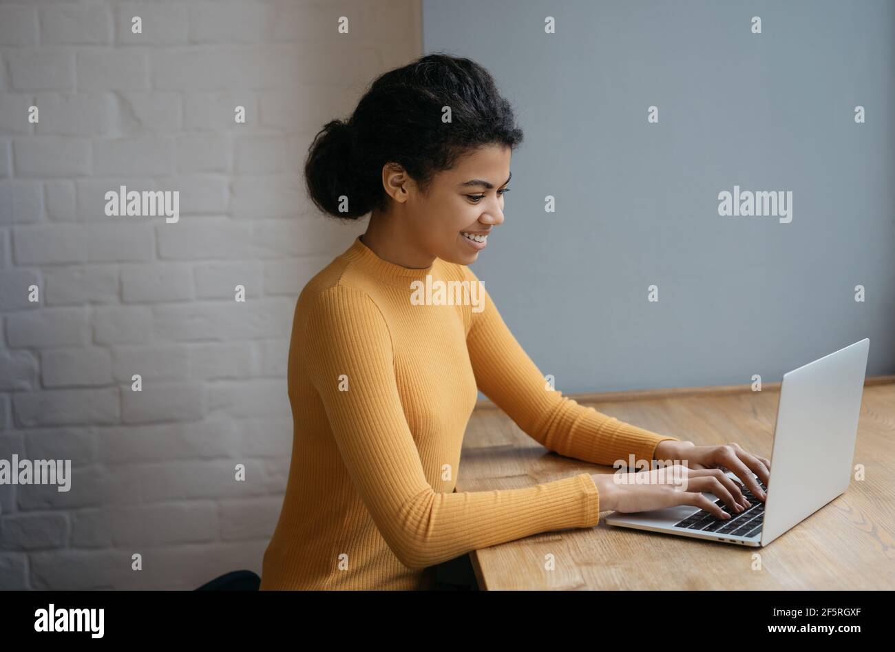 Bella donna copywriter lavoro freelance progetto, digitando, cercando informazioni. Ritratto di un giovane programmatore afroamericano di successo Foto Stock
