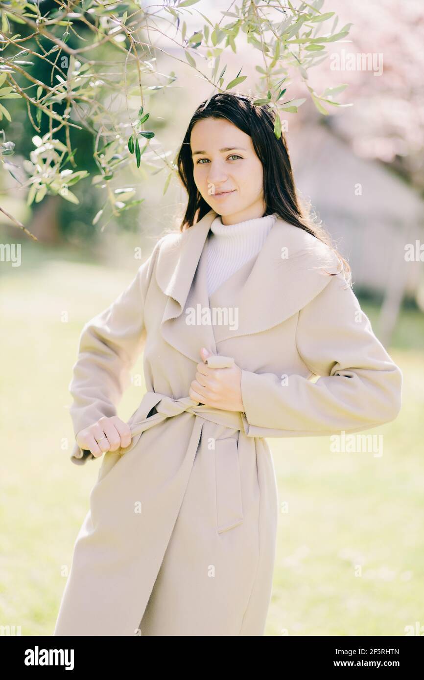stile di vita outdoor ritratto di giovane donna che indossa un cappotto di primavera Foto Stock