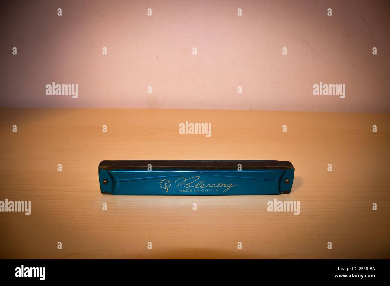 Closeup di un mouthorgan di armonica blu su un tavolo di legno Foto Stock