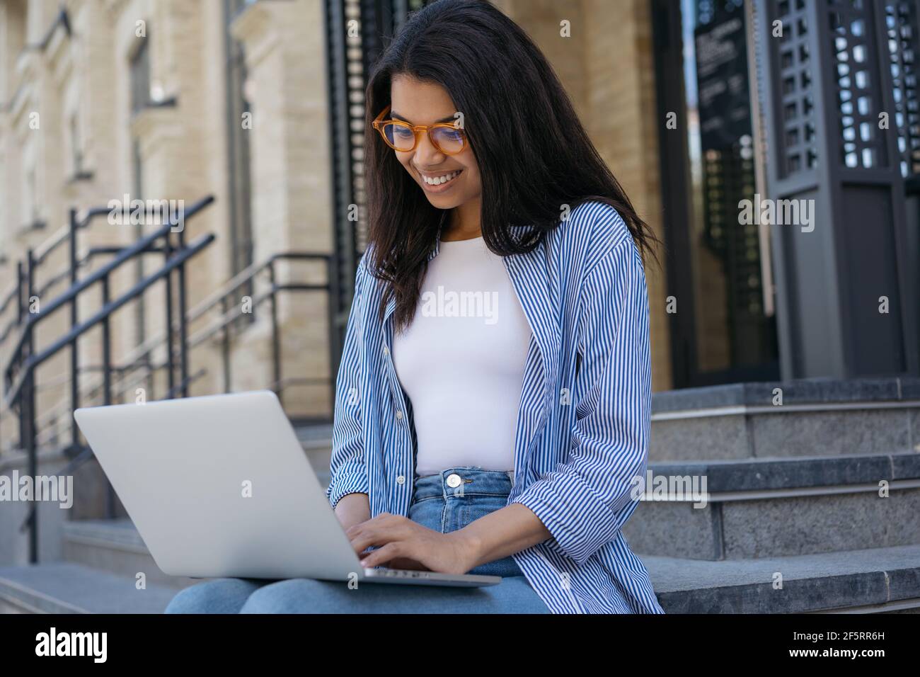 Donna d'affari afroamericana che usa il computer portatile, ricerca di informazioni, comunicazione online. Freelance che scrive sul laptop, progetto di lavoro Foto Stock