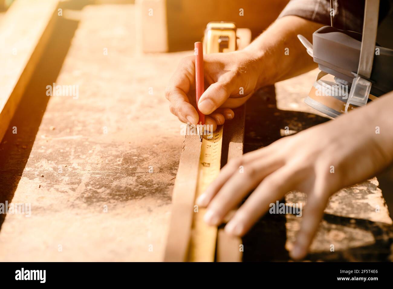 Falegname uomo che lavora in mobili legno officina, Closeup mano misurazione e marcatura su pezzo di legno. Foto Stock