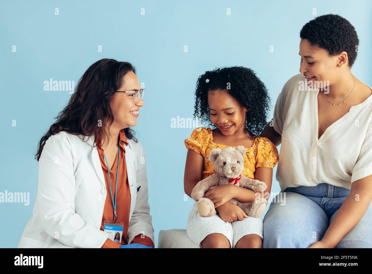 Bambina che ha esame medico da medico femminile mentre è con la madre nella clinica. Pediatra che esamina una paziente di ragazza. Foto Stock