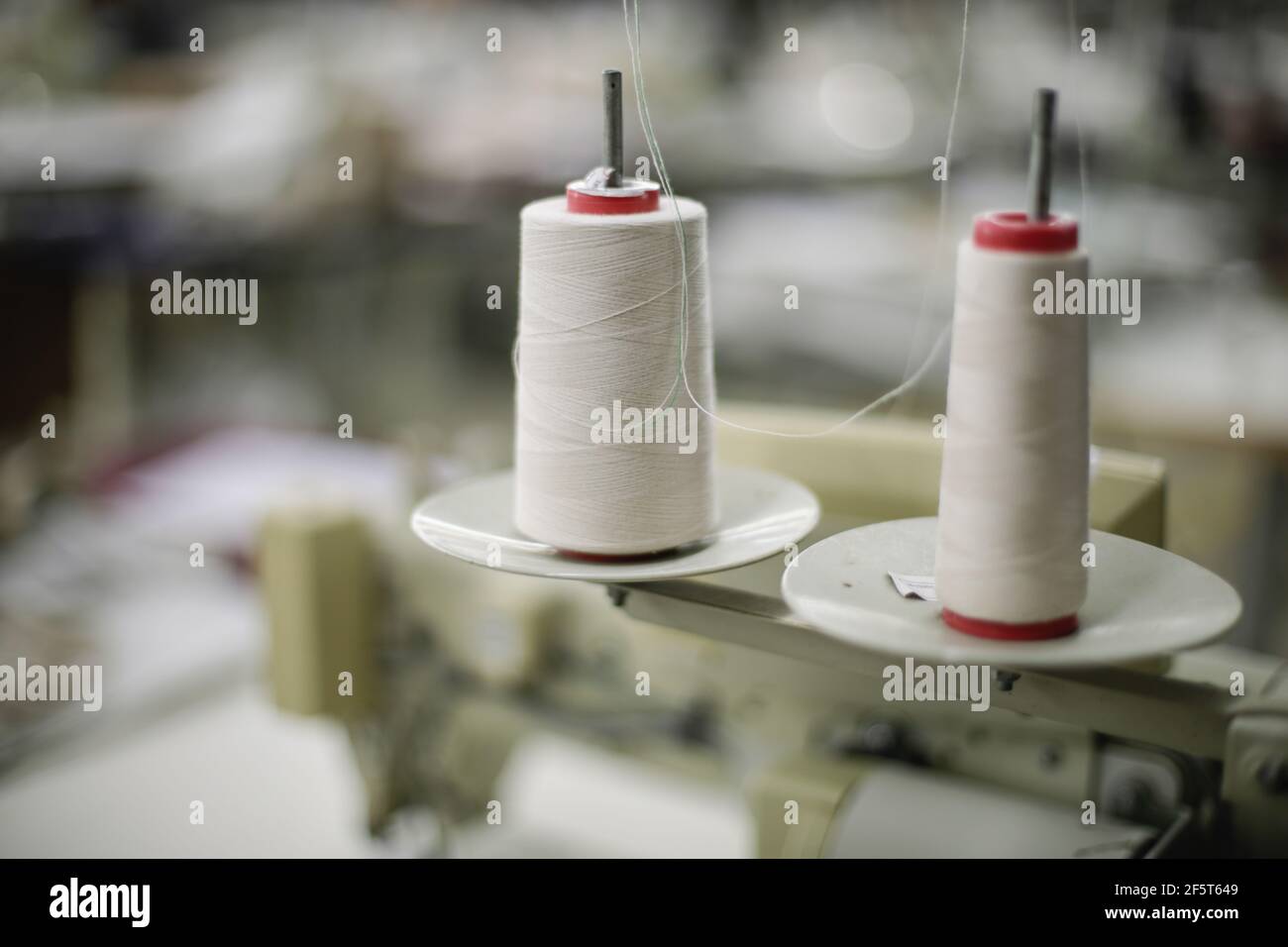 Immagine della profondità di campo poco profonda (fuoco selettivo) con bobine di filo in una fabbrica tessile. Foto Stock