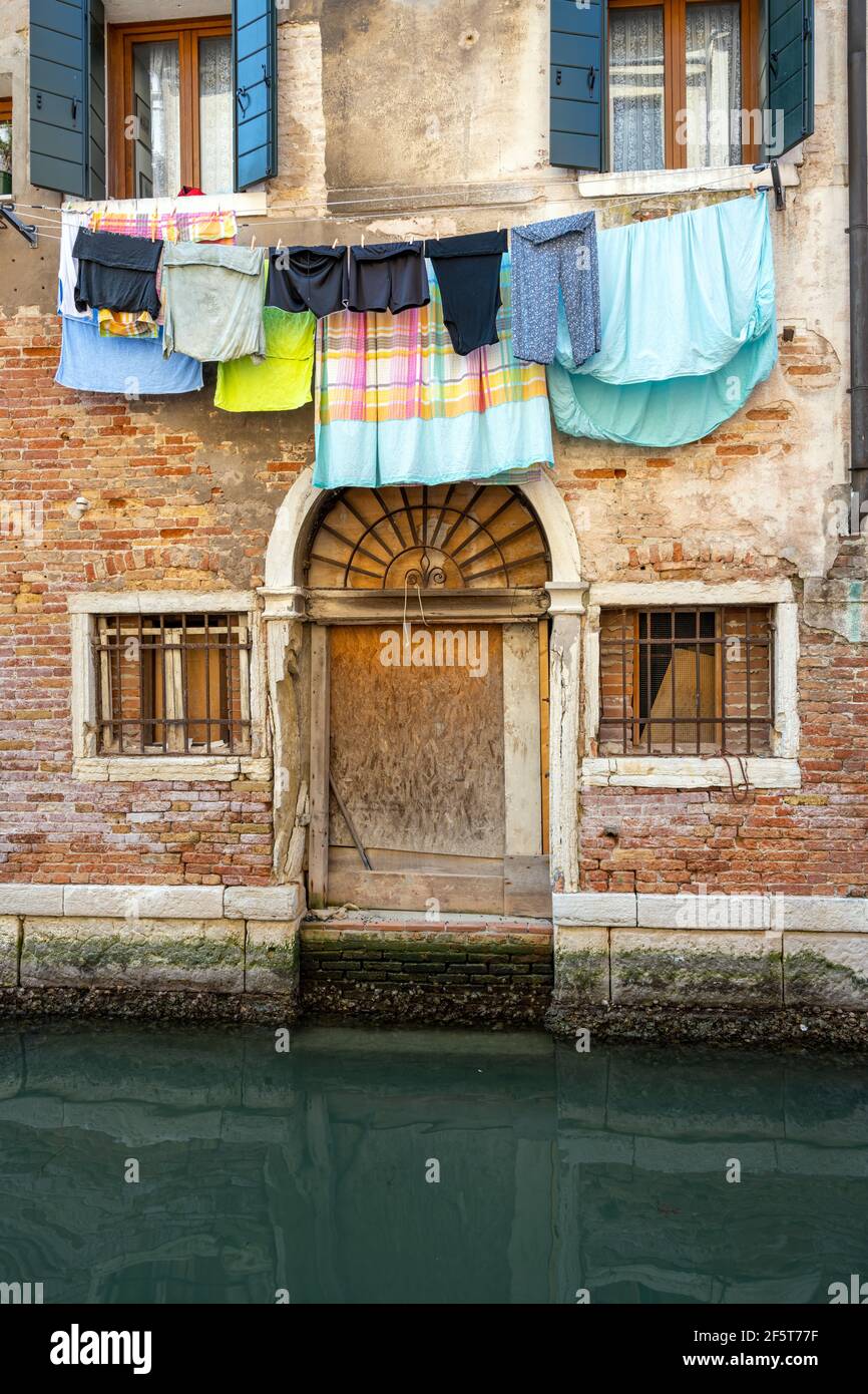 Piccolo canale a Venezia con biancheria e lavanderia Foto Stock