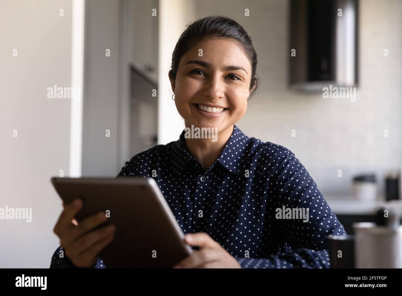 Ritratto della testa sorridente giovane donna indiana che tiene il tablet Foto Stock