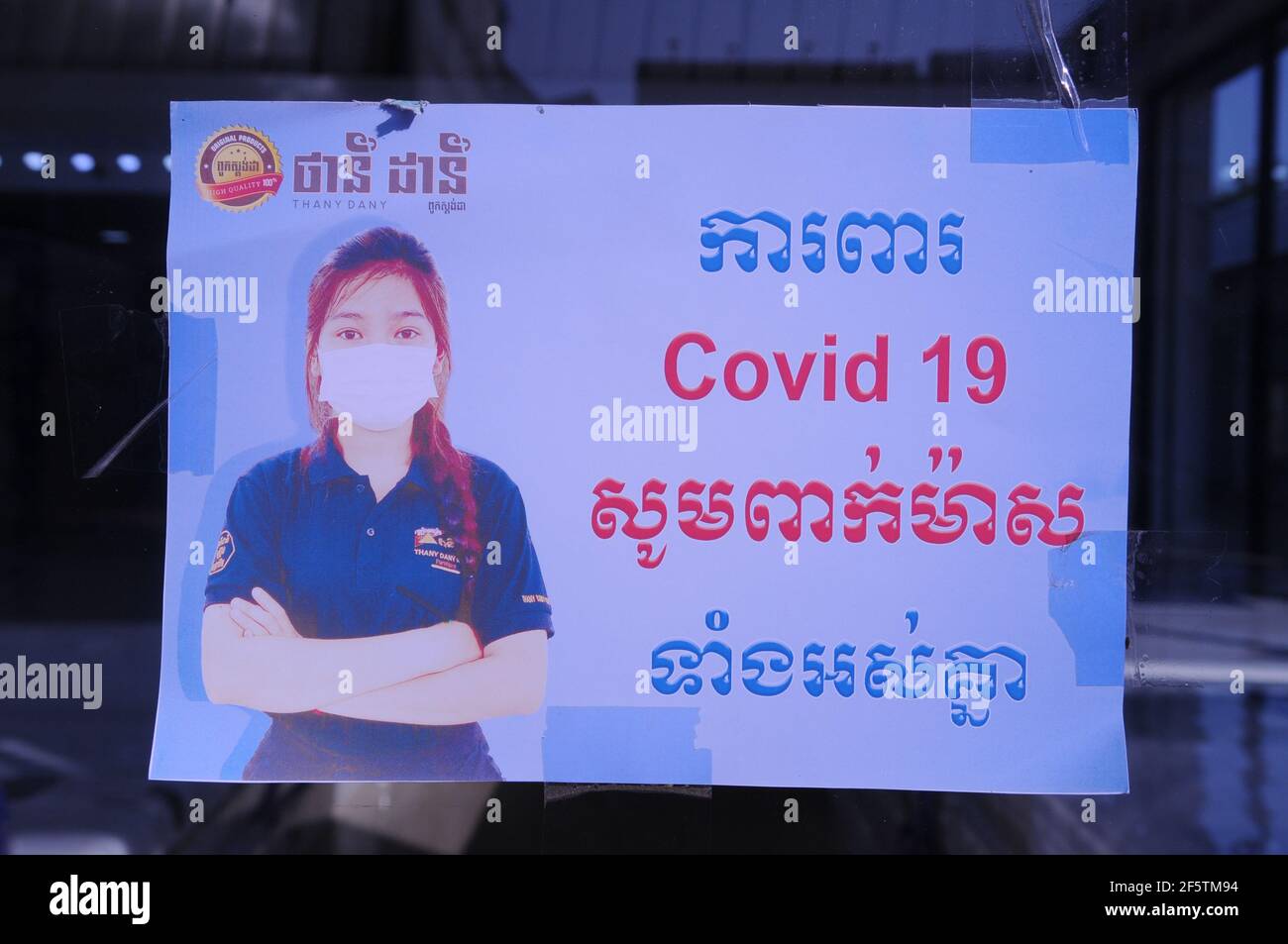 Un COVID bilingue - 19 segnale di avvertimento all'ingresso di un negozio durante la pandemia del coronavirus. Steung Meanchey, Phnom Penh, Cambogia. © Kraig Lieb Foto Stock
