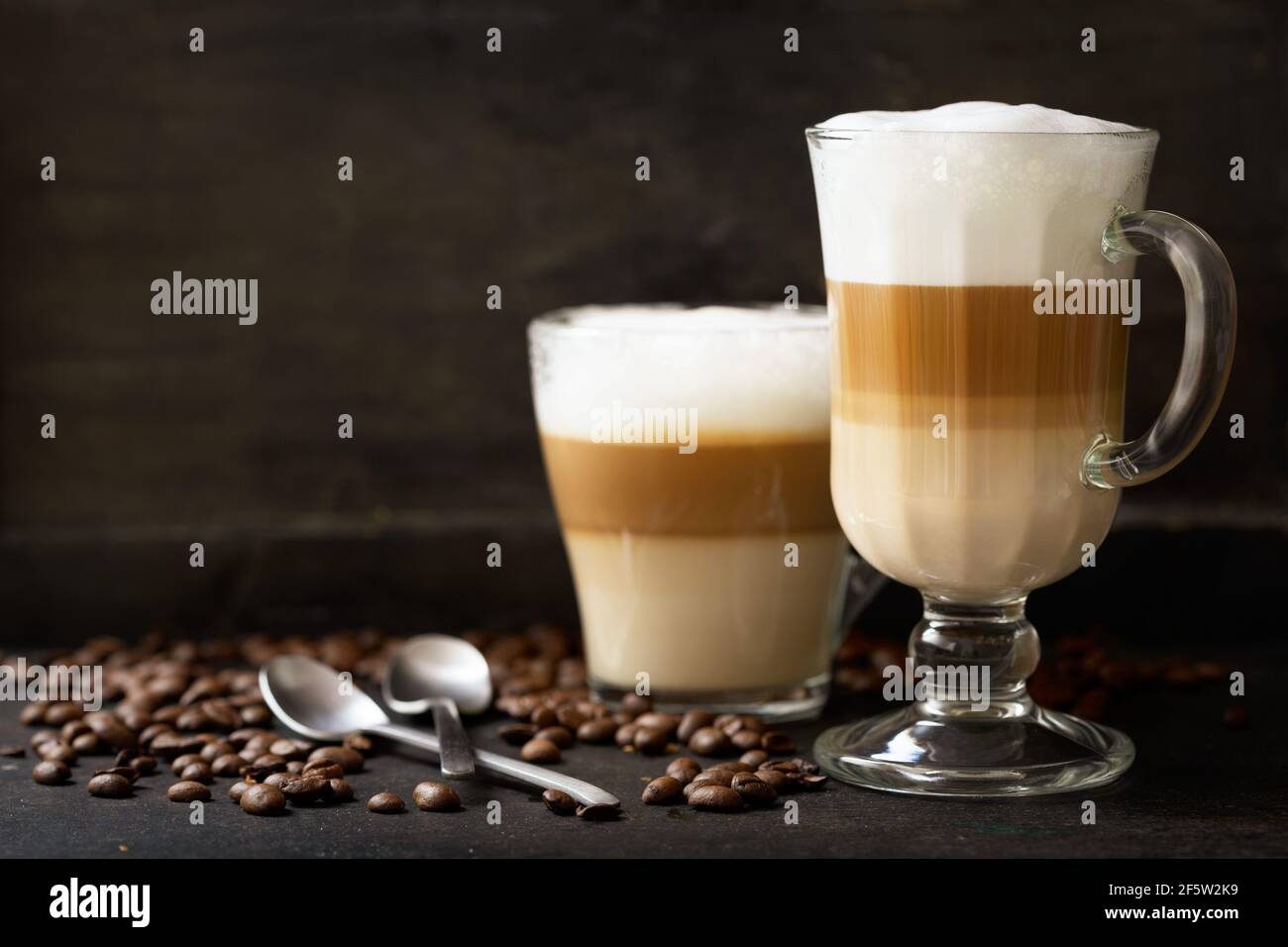 bicchieri di caffè latte macchiato su sfondo scuro Foto Stock