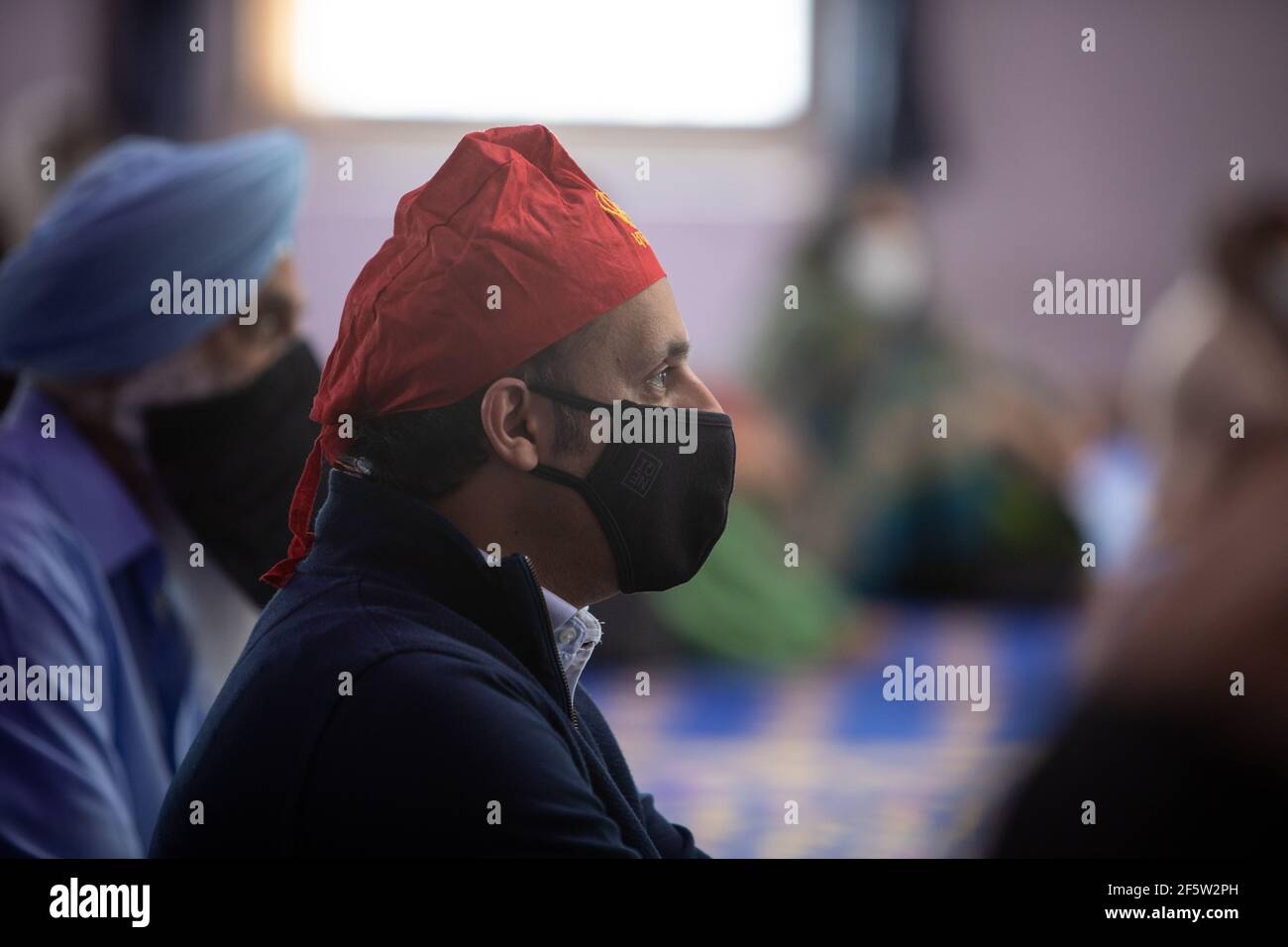 Glasgow, Regno Unito, il 28 marzo 2021. ANAS Sarwar (con copertura rossa), leader del Partito laburista scozzese, visita il Central Gurdwara Glasgow, il primo giorno di servizi per la comunità Sikh da quando le restrizioni di blocco hanno cominciato ad alleggerire. Sarwar stava intraprendendo la visita come parte della campagna elettorale per le elezioni parlamentari scozzesi del 6 maggio. Photo credit: Jeremy Sutton-Hibbert/Alamy Live News Foto Stock