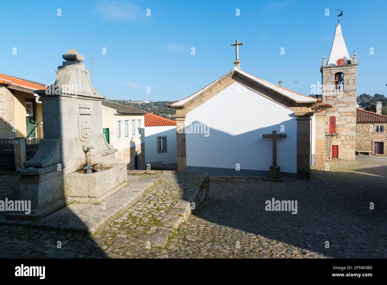 Il villaggio di Castelo Mendo, Almeida, Portogallo. Antica fontana e chiesa Foto Stock