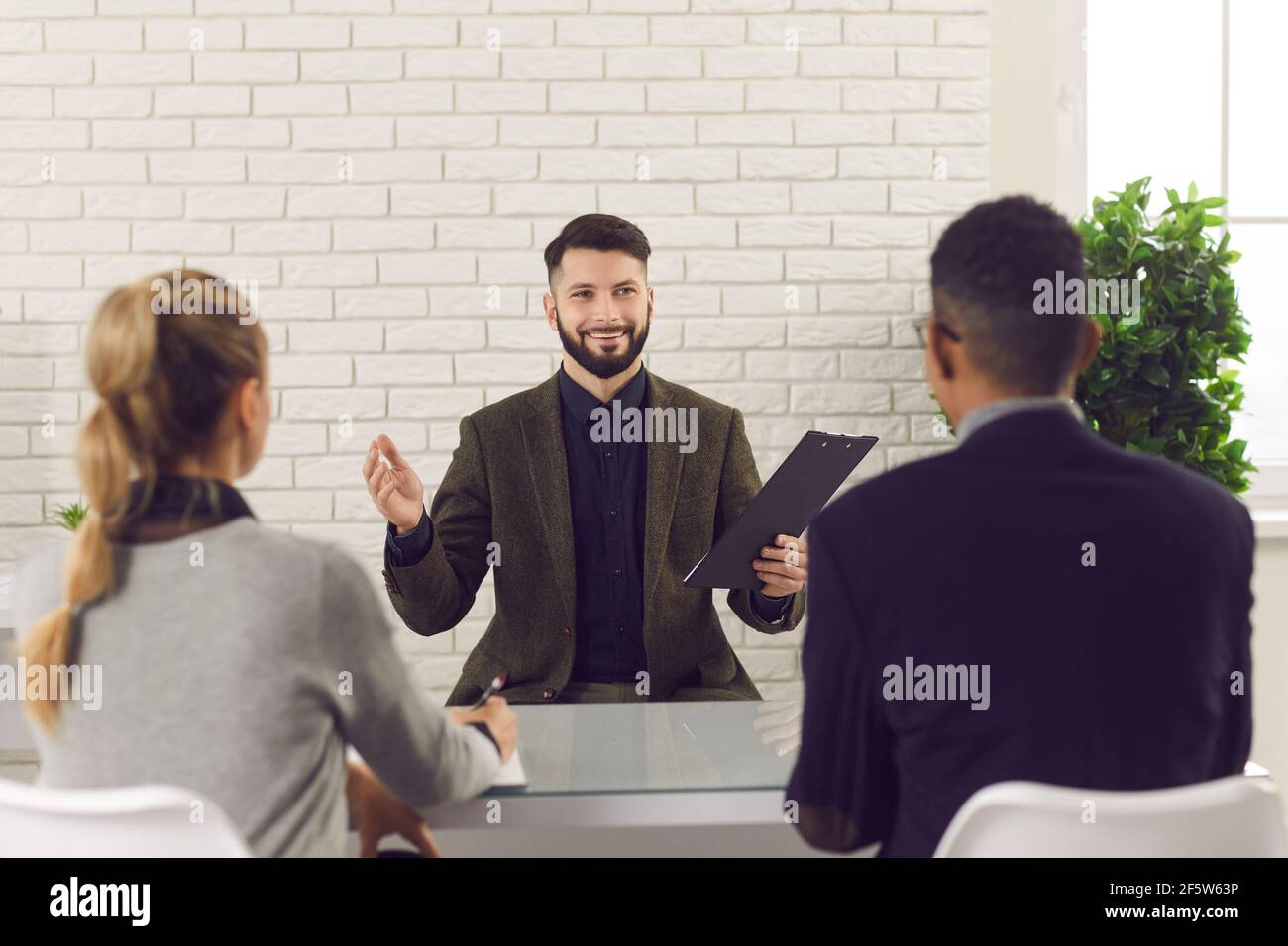 Felice candidato di lavoro che racconta la sua esperienza in un'intervista Con i responsabili delle risorse umane Foto Stock