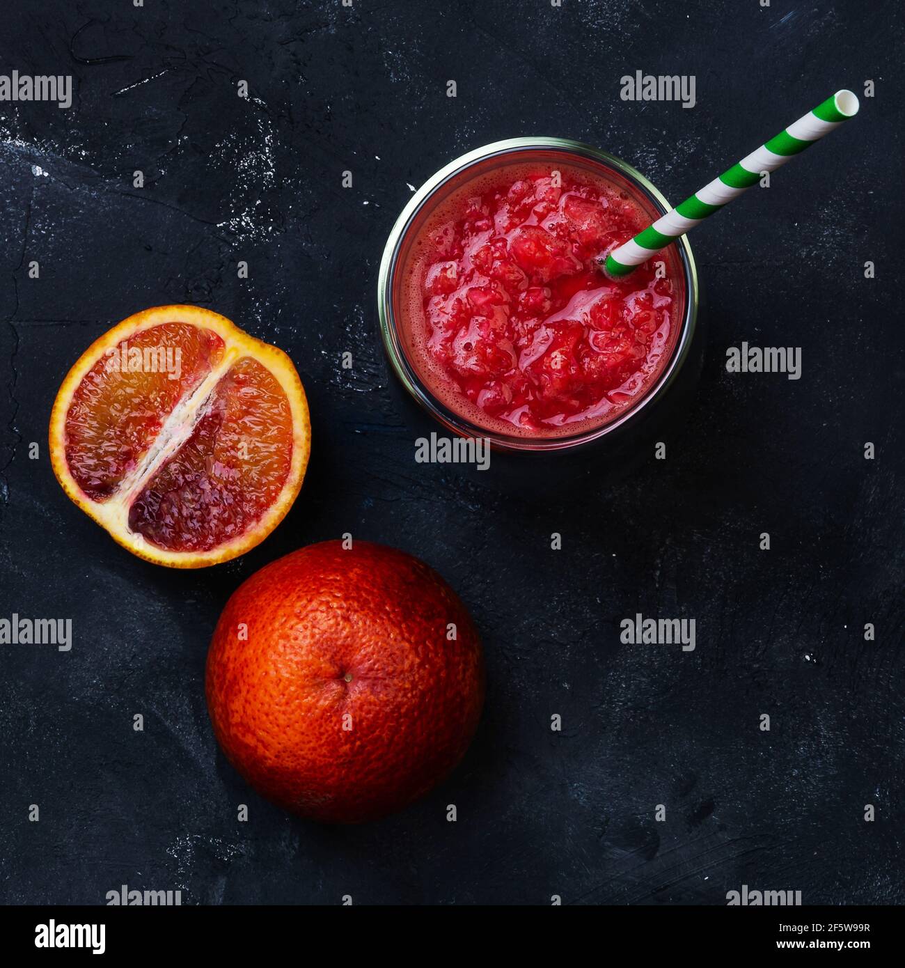 Succo d'arancia rosso in un bicchiere. Cocktail dalle arance siciliane. Idea estiva creativa minima Foto Stock