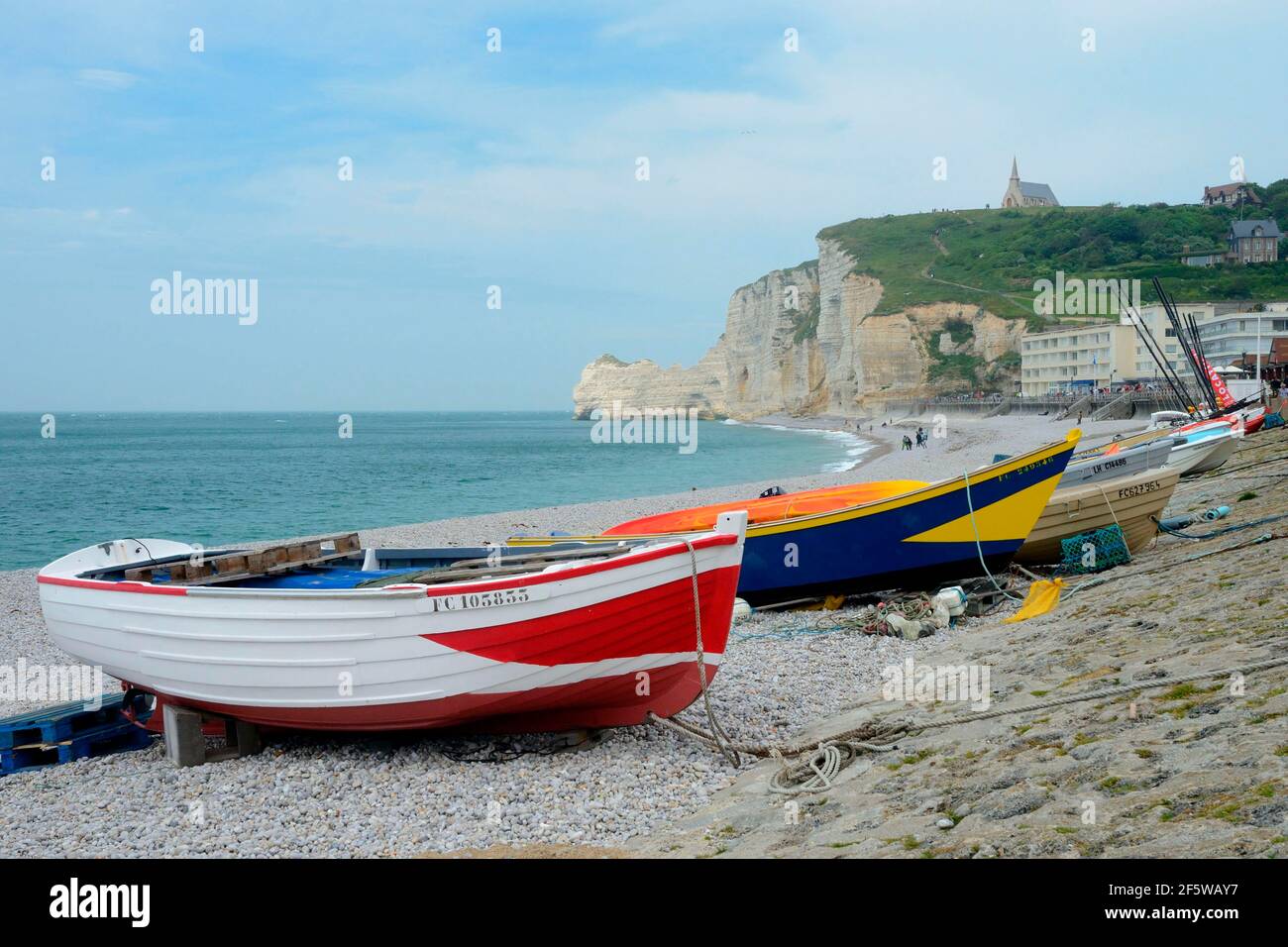 Barche sulla spiaggia, Falaise d'Amont e Chapelle Notre Dame de la Garde, lungomare, Etretat, Normandia, Francia Foto Stock