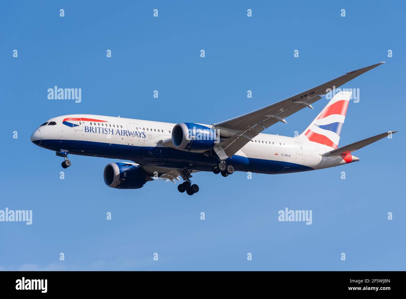 British Airways Boeing 787 aereo di linea a reazione Dreamliner G-ZBJK in finale per atterrare all'aeroporto Heathrow di Londra, Regno Unito, in cielo blu. Compagnia aerea IAG Foto Stock