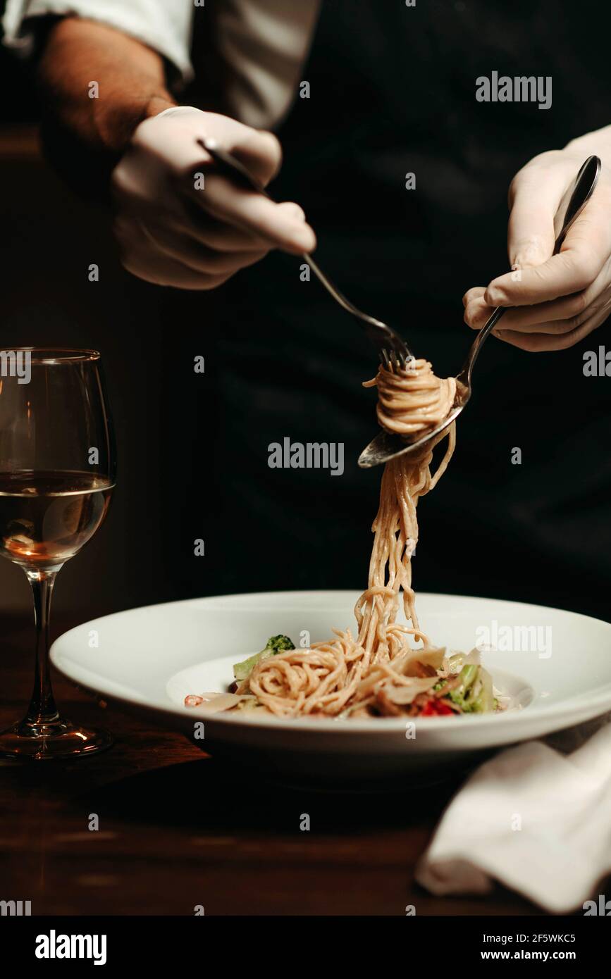 Primo piano di una pasta che si avvolge a mano su una forchetta Foto Stock