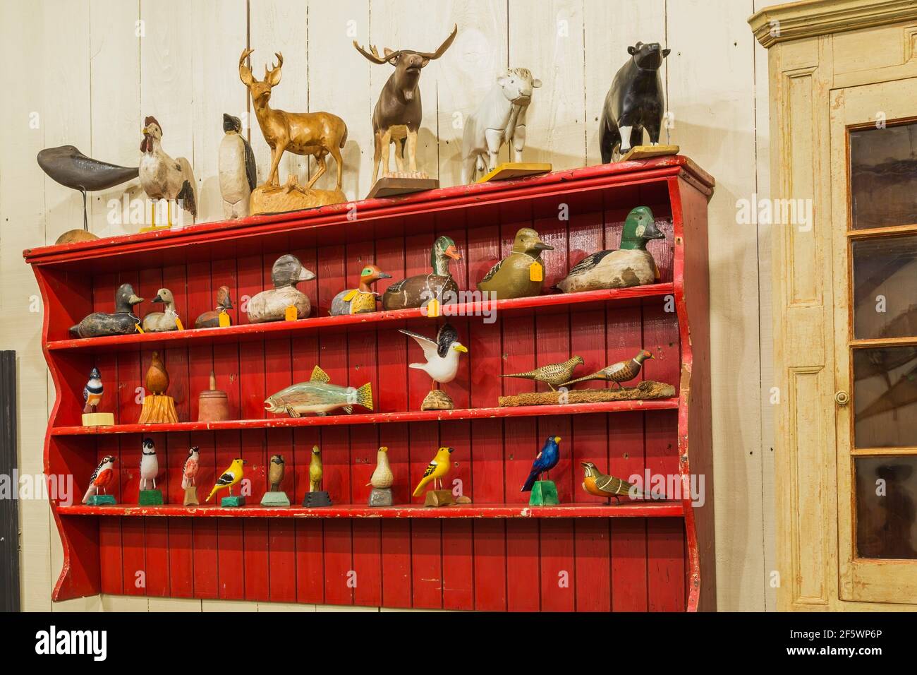 Anatre, sculture in legno di uccelli e animali in esposizione all'interno di un vecchio fienile in legno Foto Stock