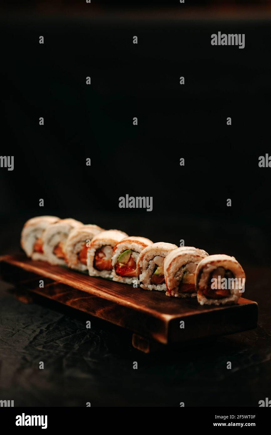 Set di sushi con anguilla e avocado su sfondo nero Foto Stock