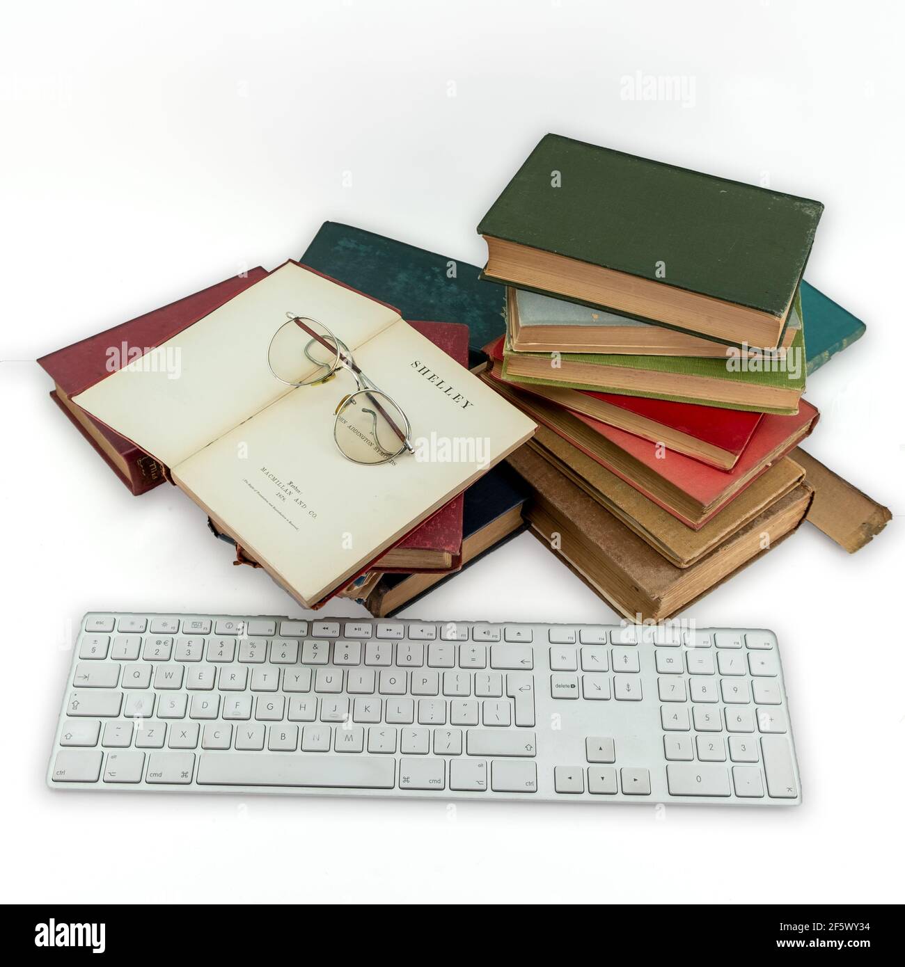 Tastiera Apple e vecchi libri d'epoca in inglese su bianco sfondo Foto Stock