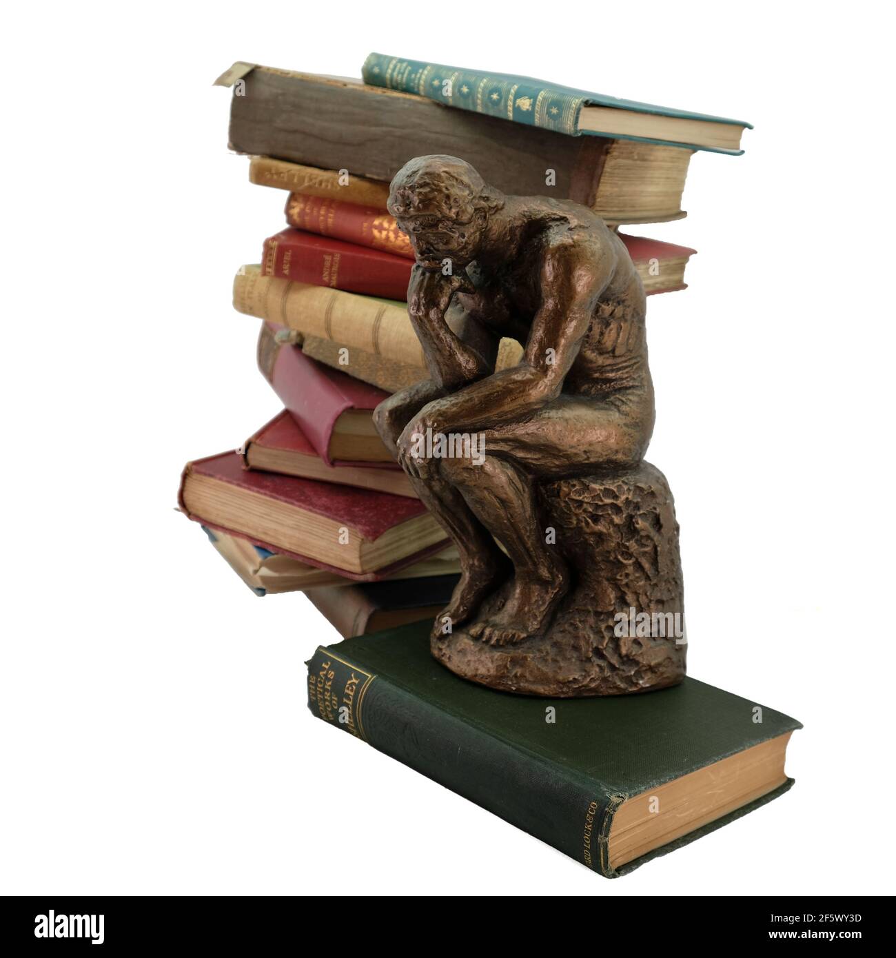 Thinking Man statua anteriore di vecchi libri d'epoca con bianco sfondo Foto Stock