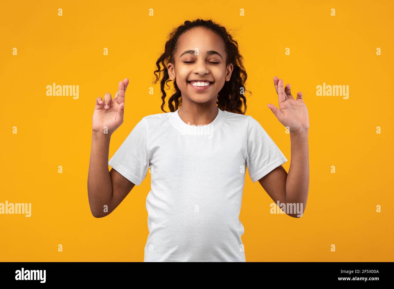 Ragazza afroamericana speranzosa che le attraversa le dita Foto Stock