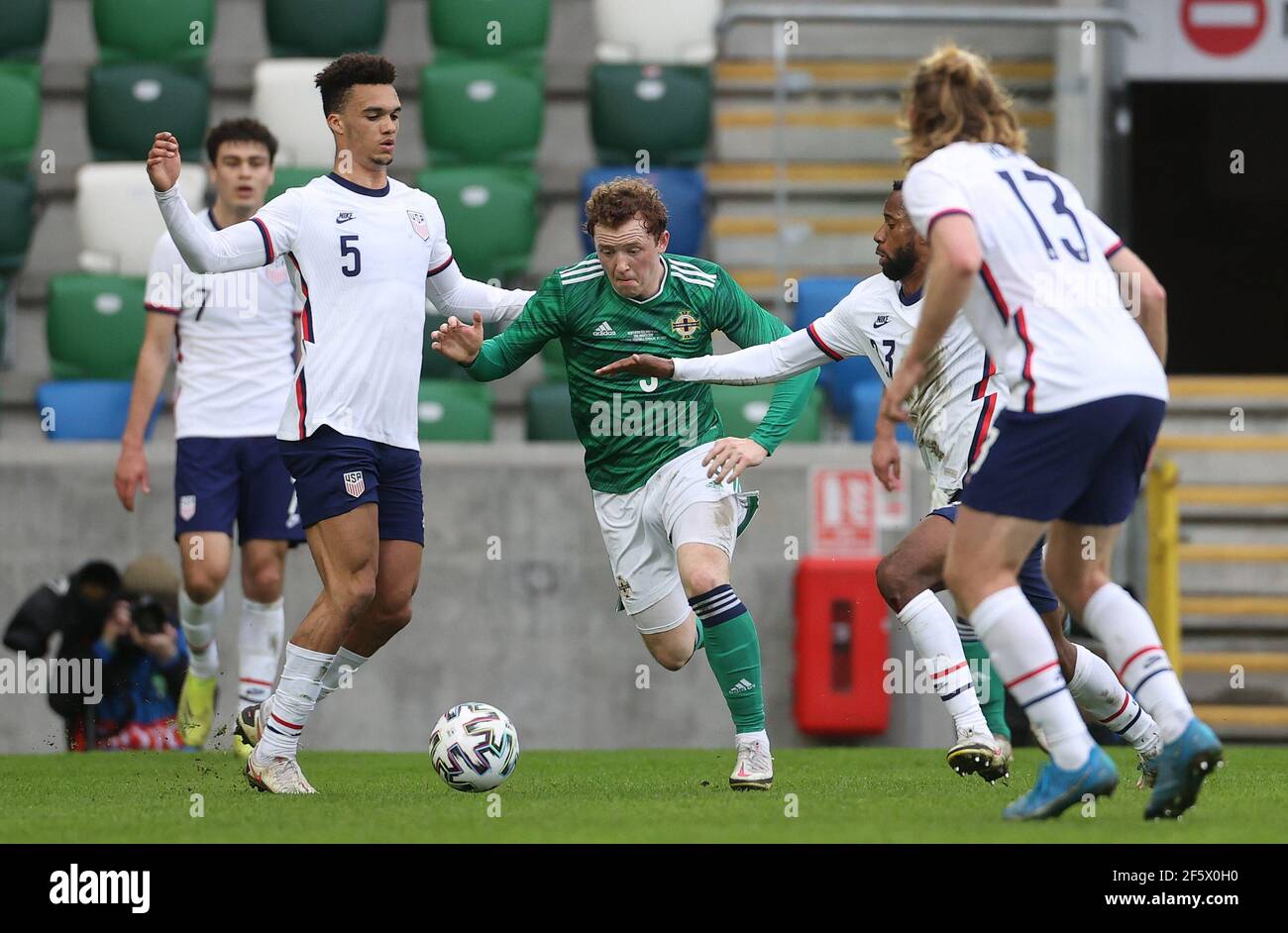 Shayne Lavy (centro) dell'Irlanda del Nord si allontana dal Kellyn Acosta degli Stati Uniti durante l'amichevole internazionale al Windsor Park, Belfast. Data immagine: Domenica 28 marzo 2021. Foto Stock