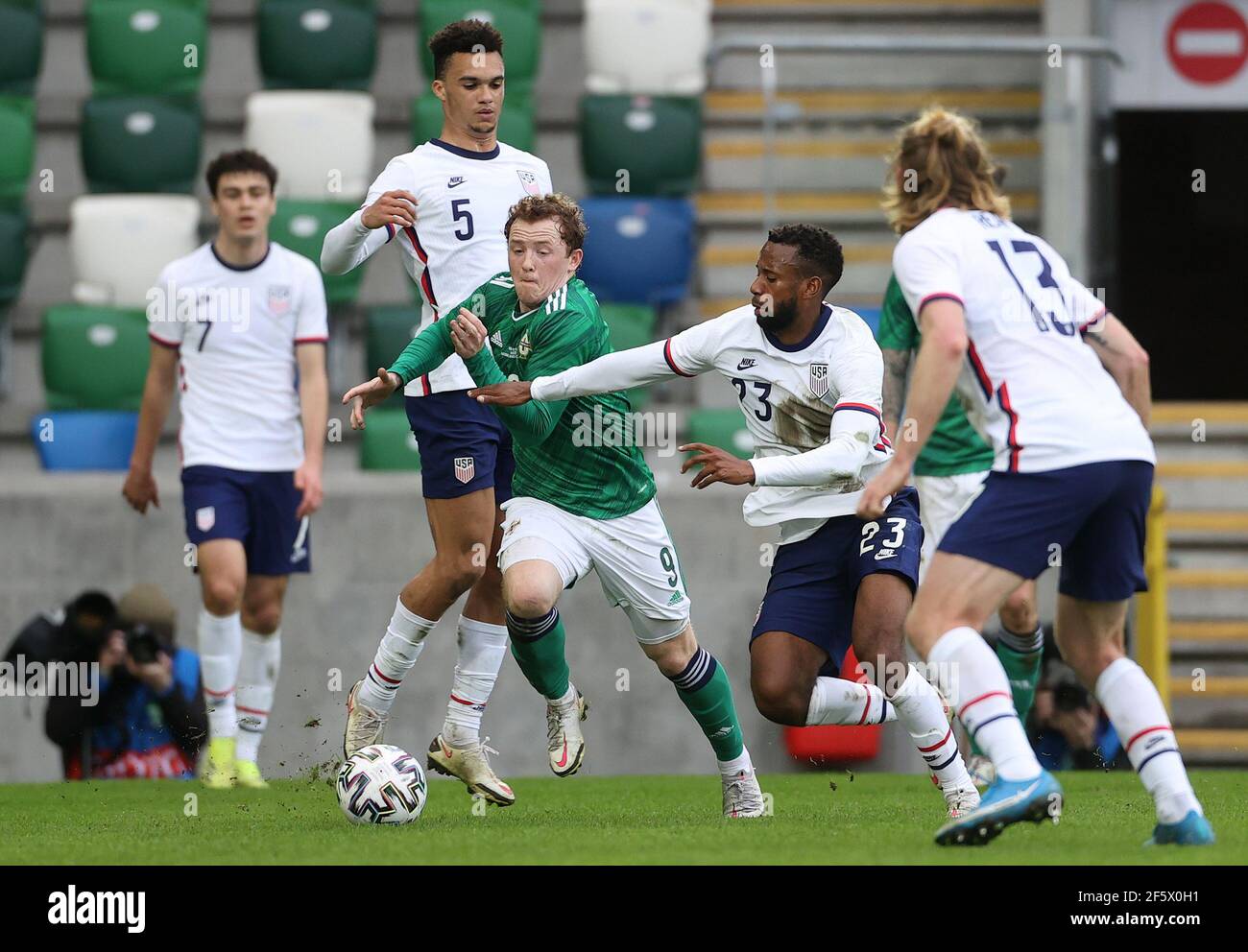 Shayne Lavy (centro) dell'Irlanda del Nord si allontana dal Kellyn Acosta degli Stati Uniti durante l'amichevole internazionale al Windsor Park, Belfast. Data immagine: Domenica 28 marzo 2021. Foto Stock