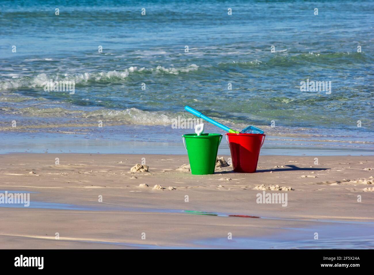 Secchi di sabbia rossa e verde sulla spiaggia di Destin, Florida Foto Stock