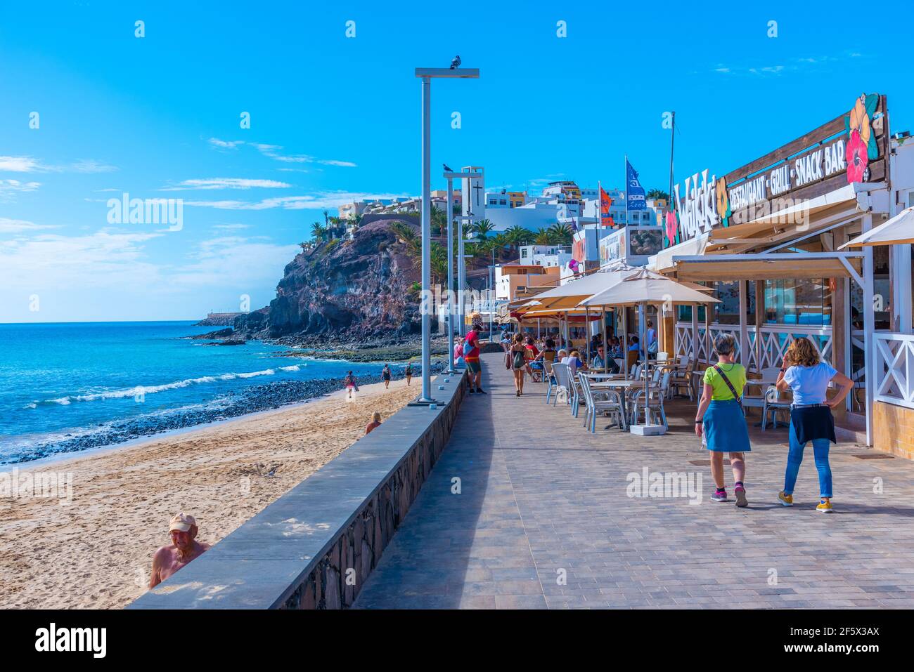Morro Jable, Spagna, Janury 24, 2021: La gente sta passeggiando su una passeggiata a Morro Jable, Fuerteventura, isole Canarie, Spagna. Foto Stock